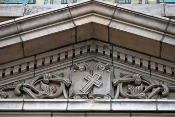 A frieze over a church entryway with a prominent cross as the centerpiece_20101003_03690.
