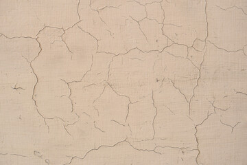 Close-up of a Cracked and Weathered Wall with Beige Paint Texture