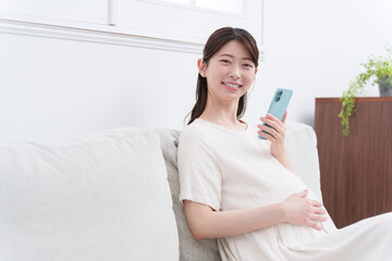 スマホを使う笑顔の妊婦