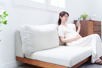 Fototapeta premium スマホを使う笑顔の妊婦