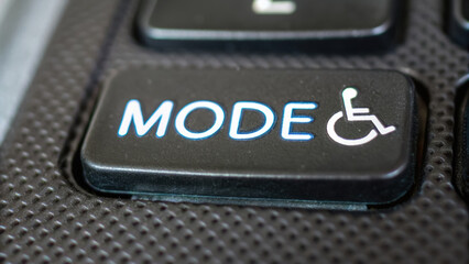 Mode button with wheelchair symbol on black textured surface representing ai technology for customer service in startup rf environment