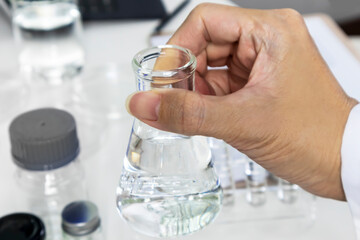Researchers pick up scientific experiment bottles to study and develop new chemical formulas