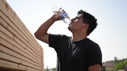 A man cools off with water during outdoor activity under the sun. - Powered by Adobe