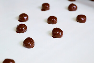 Chocolate-coated grillage nut brittle is produced on a conveyor belt in a manufacturing facility during the day