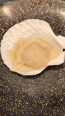 Scallops on a black plate. Natural food.