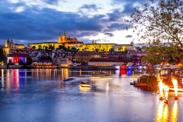 Beautiful twilight view of the historical buildings on Vltava Riverbanks during boat festival in Prague, Czech Republic