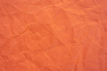 Fototapeta premium Full frame shot of crumpled orange colour paper sheet texture and background.