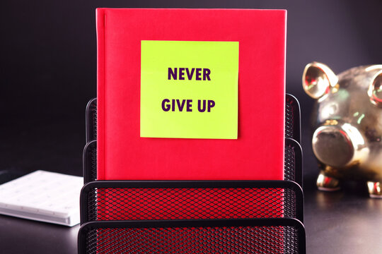 Naklejki Business development challenge concept and effort success idea. Never give up written on a yellow sticker stuck on a red business notebook