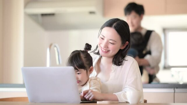 自宅のリビングで仕事をするママと家事をするパパ　リモートワーク、共働きや主夫のイメージ動画