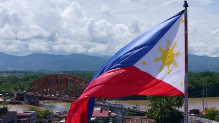 Philippine flag flying above Butuan City Caraga Mindanao with Magsaysay Bridge and Agusan River in the Background.