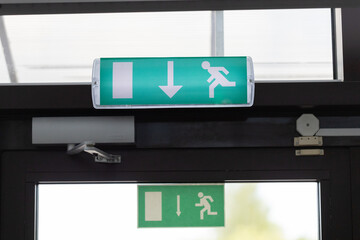 Green Emergency Exit Sign Above Door Indicating Safe Evacuation Route