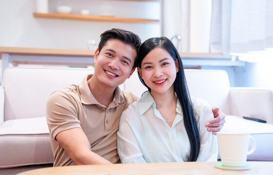 Smiling couple enjoying time together in their home Warm smiles showcasing their affection - Powered by Adobe