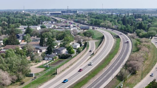 Highway with a lot of traffic and houses in the background. Scene is busy and bustling