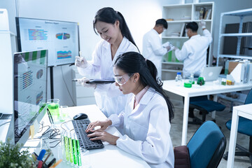 Obraz premium In the laboratory, a biologist uses advanced technology and computer analysis to compare data from experiments, conducting research to uncover new scientific insights in biology.