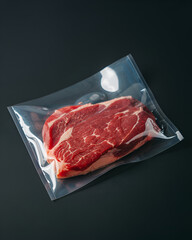 A photograph of a thick cut of raw, vibrant red beef inside a clear polythene bag