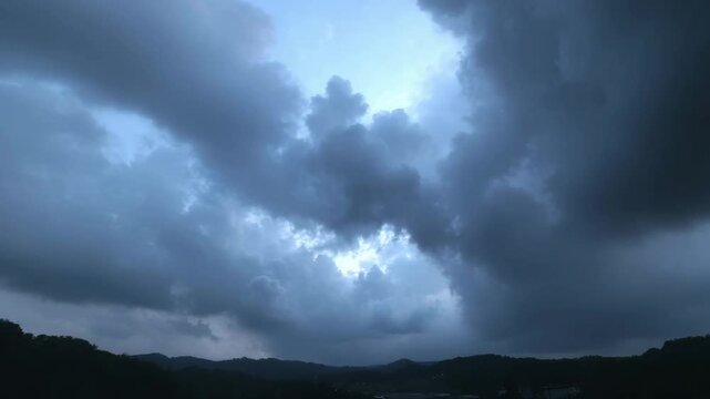 Dark storm clouds gather over mountain landscape with dramatic sky and moody cloud filled mountain