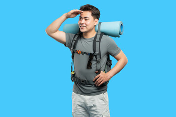 Focused backpacker gazes into the distance with hand shielding eyes ready for adventure