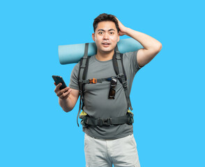 Lost hiker consults phone for directions looking surprised while wearing a backpack