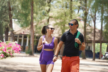 Naklejka premium Young couple engaging in stretching exercises with resistance bands in the park