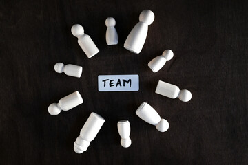 wooden peg dolls in a team - concept photo representing team work and cooperation
