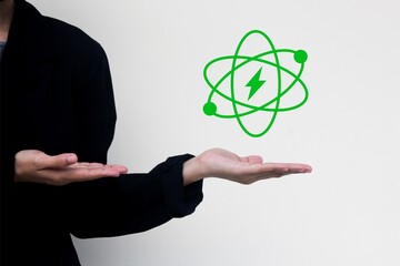 Business person holding glowing atom icon with lightning bolt, symbolizing nuclear energy,...
