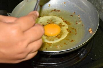 Frying egg, sunny upside on a pan