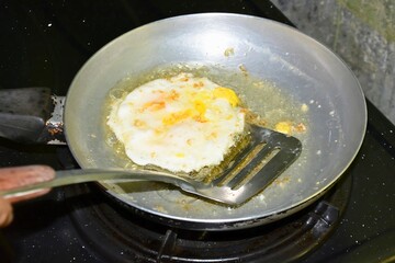 Frying egg, sunny upside on a pan