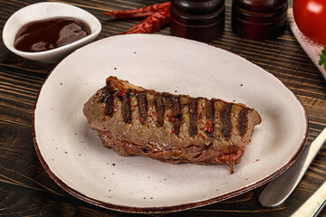 Grilled beef striploin steak with sauce