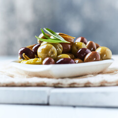 Various olives on bright wooden background. Close up. Copy space.	
