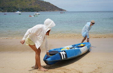 A young couple launches a kayak for a sea voyage