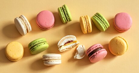Obraz premium broken round macarons with crumbs on a yellow background, delicious dessert, top view