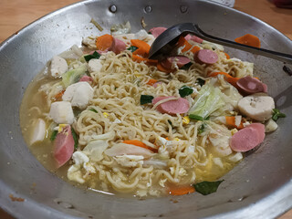 Indonesian Instant Noodles with Vegetables, Sausage, and Meatballs in a Wok