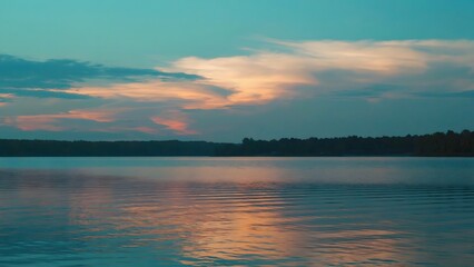 Obraz premium Serene lake scene during sunset with calm water and colorful sky
