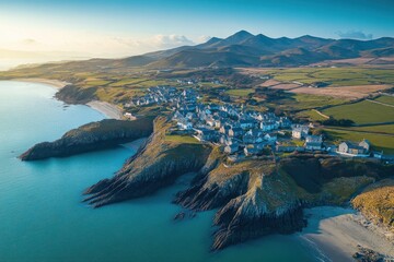 Obraz premium Fishing village on Holyhead Island captured from above during golden hour, Holyhead island fishing village aerial view circling sunlit homes mountain and townhouse property