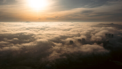 Aerial photography of sea of ​​clouds at sunset under sunlight
