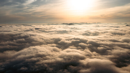 Aerial photography of sea of ​​clouds at sunset under sunlight
