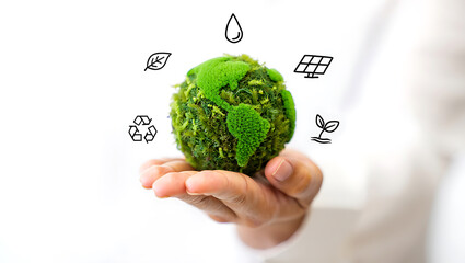 Person holding a green earth symbol with icons of environmental sustainability