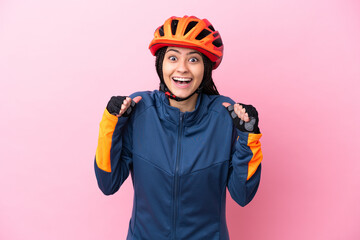 Teenager cyclist girl isolated on pink background celebrating a victory in winner position
