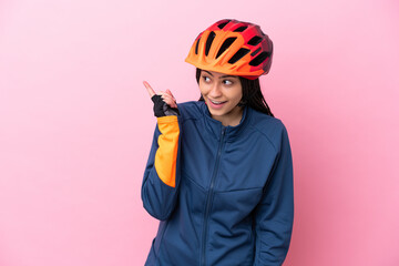 Teenager cyclist girl isolated on pink background intending to realizes the solution while lifting a finger up