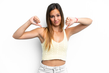Young caucasian woman isolated on white background showing thumb down with two hands