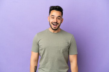 Young caucasian man isolated on purple background with surprise facial expression