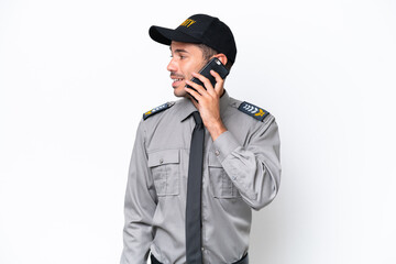 Young safeguard man over isolated white background keeping a conversation with the mobile phone...