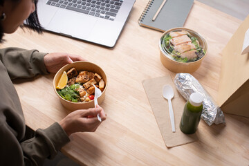Asian woman eating healthy meal while working, Businesswoman having a lunch break at the office