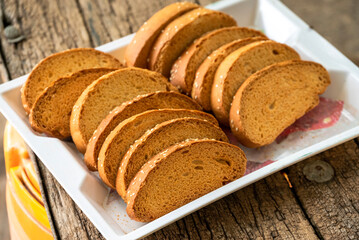 Crispy rusk, Biscuits cake rusk over wooden background , a crunchy snack infused with traditional spices, perfect for tea or coffee. A delightful treat for your mornings or tea time