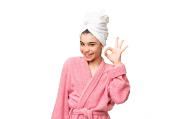 Little girl in a bathrobe over isolated chroma key background showing ok sign with fingers