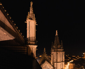 Duomo di Orvieto at night. A man stands on the tower of the Cathedral