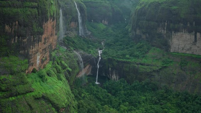 4K shot of Devkund waterfall as seen from Savlya Ghat View Point at Tamhini Ghat near Pune in Maharashtra, India. Scenic view of Devkund waterfall from a mountain. Natural monsoon background in India.