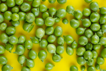 close-up of fresh green peas on yellow background