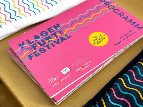 Colorful klagenfurt festival program booklet on display table