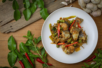 Spicy stir-fried catfish (Pad Cha Pla Dook) on a white plate, a popular and flavorful Thai dish. The dish features pieces of catfish stir-fried with herbs, spices, chili peppers and Original Thai food